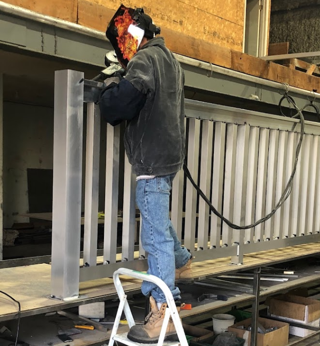 man welding aluminum in shop